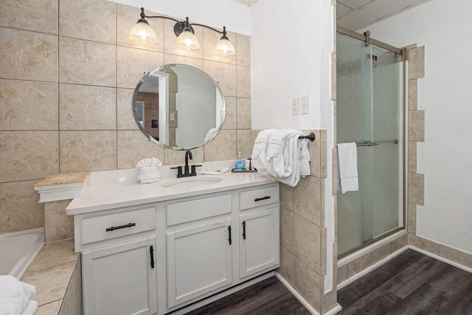 Your private spa-like bathroom features elegant tile, premium fixtures, and fluffy towels ready for your relaxing retreat.