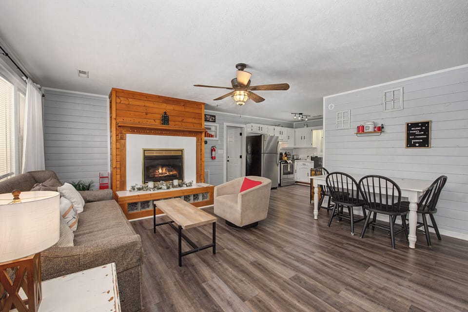 Cozy up by your gas fireplace while enjoying the open-plan living space with modern kitchen and charming farmhouse details.