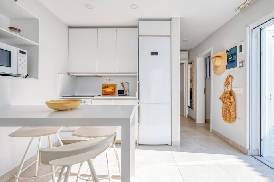 Fully equipped kitchen with oven, microwave, coffee maker, and utensils, next to the dining table