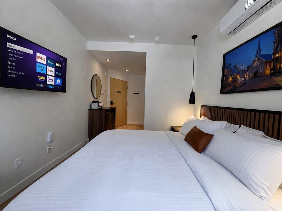 Détendez-vous dans cette chambre moderne et climatisée avec grand lit et télévision connectée. Son design épuré et lumineux offre un cadre idéal pour un séjour confortable.