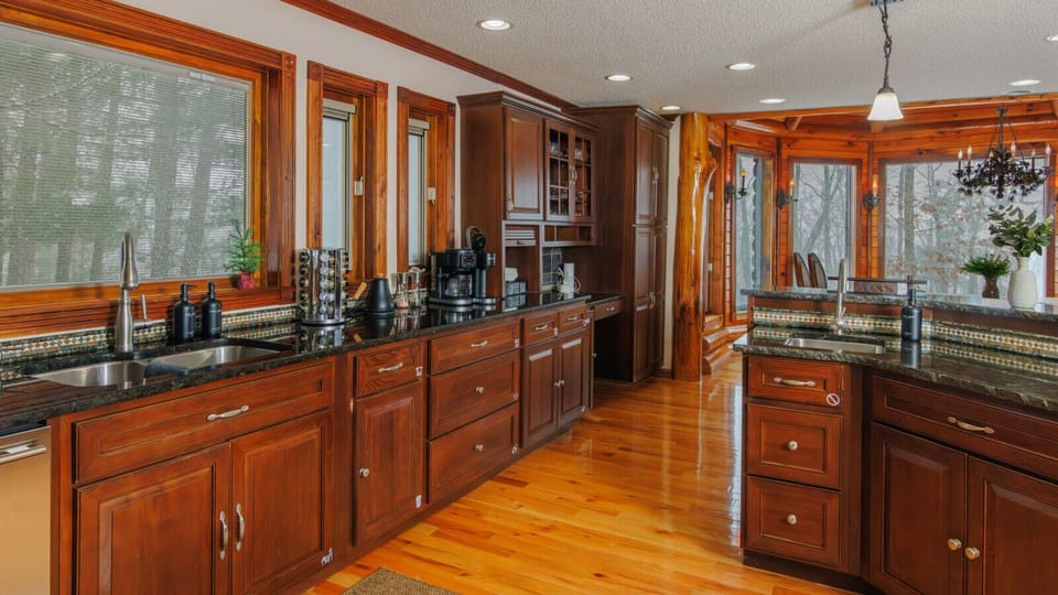 Large kitchen with double sinks, coffee station, and forest windows keeps group breakfasts flowing before Gorge adventures