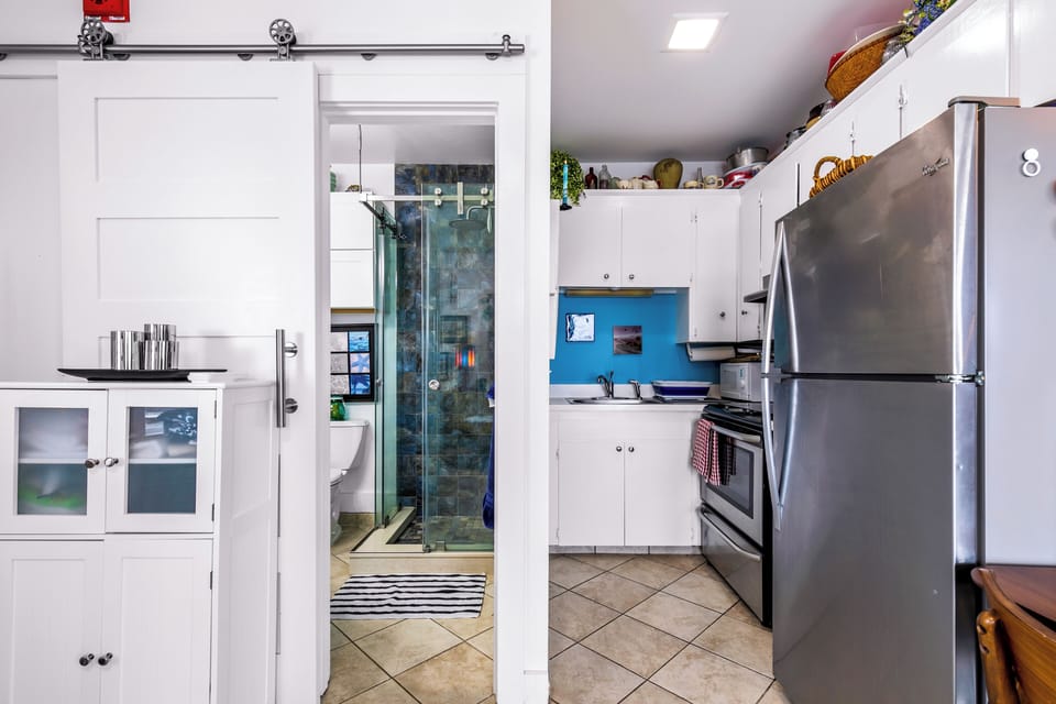 Bright kitchen with stainless appliances & sleek bath with glass shower