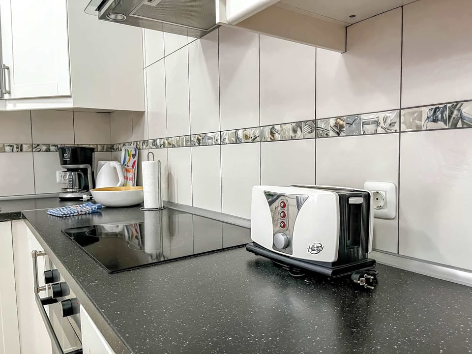 Coffee maker, cookware, dishes, silverware, microwave, oven, and refrigerator. 