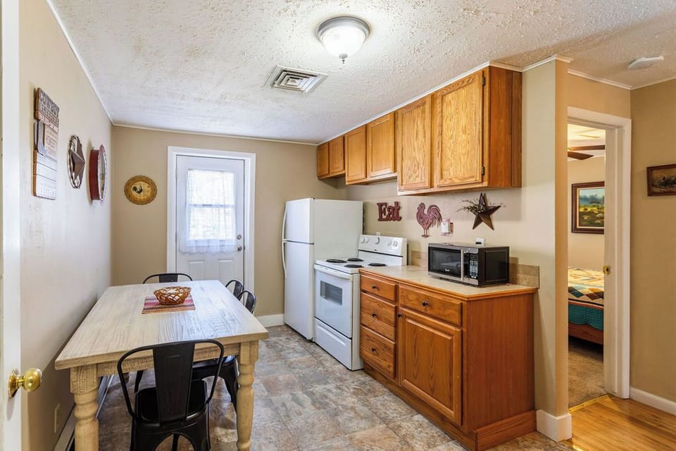 Your fully equipped kitchenette awaits with warm wood cabinets, modern appliances, and charming country touches—perfect for preparing home-cooked meals.