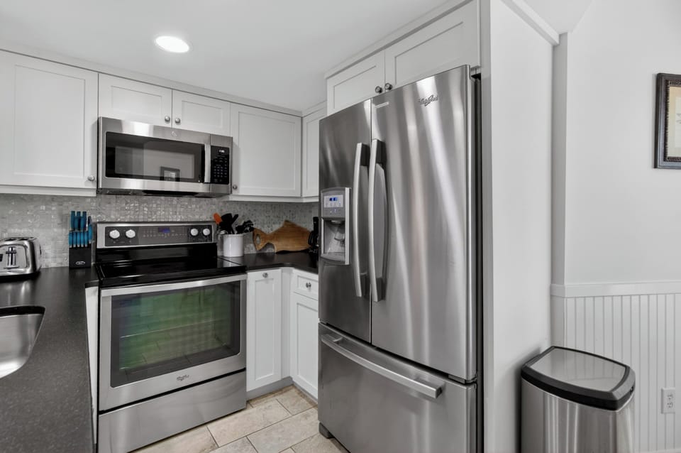 Your fully-equipped kitchen features sleek stainless steel appliances, bright white cabinetry, and elegant countertops—everything you need to whip up a delicious meal or morning coffee during your stay.