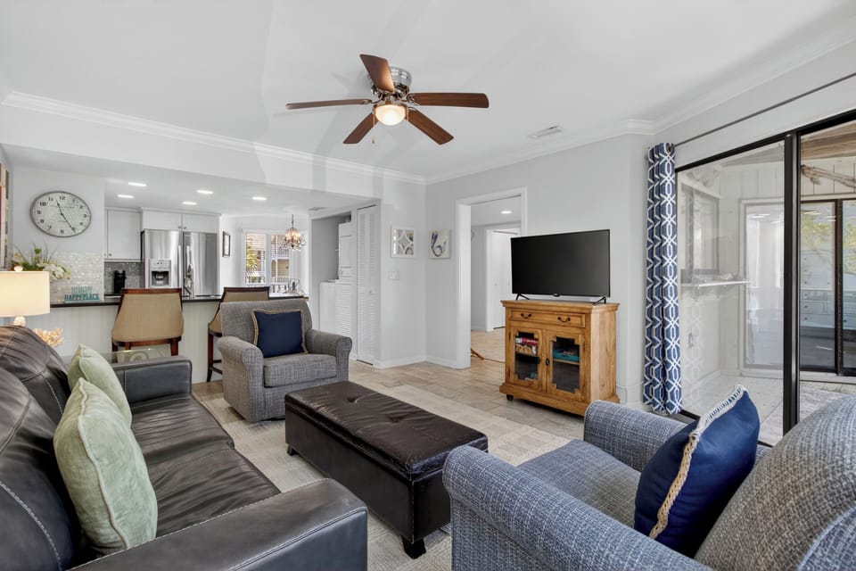 Unwind in your bright, open living room featuring plush seating, a smart TV for movie nights, and a stylish ceiling fan to keep you cool and comfortable.