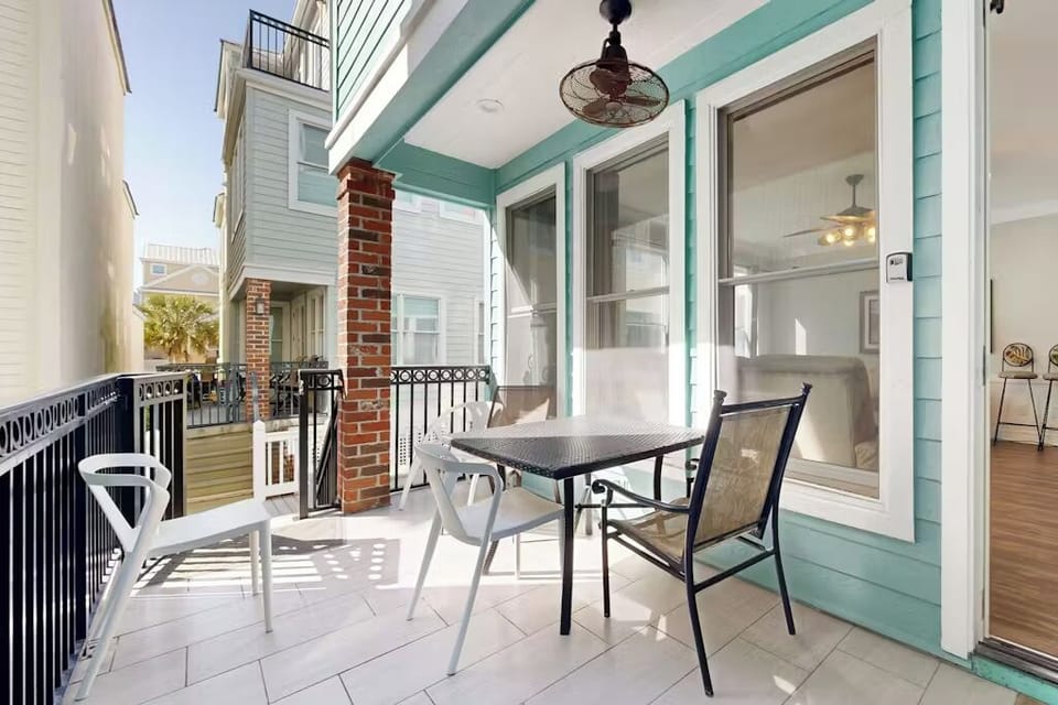 Enjoy your morning coffee on this charming turquoise balcony with comfortable seating and refreshing ceiling fan overhead.