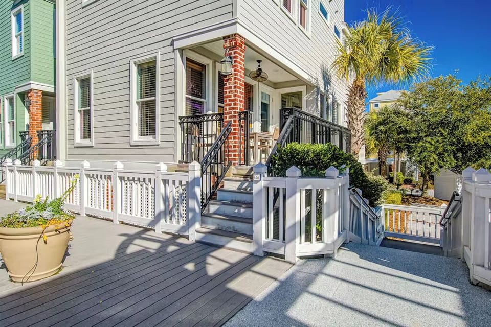 Charming coastal entrance with brick columns and white railings creates a welcoming arrival in this sunny neighborhood.