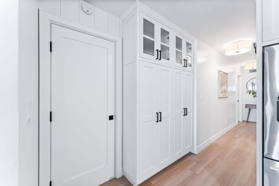 The washer and dryer are neatly tucked away behind this door.
