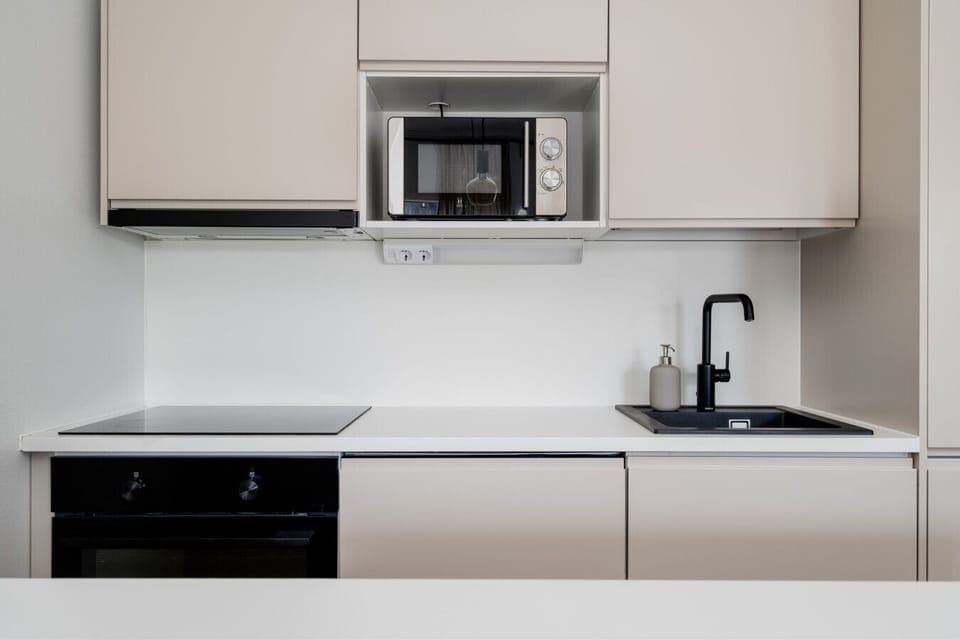 The kitchen features an induction stovetop, integrated microwave, and a dishwasher to make cleanup quick and effortless.