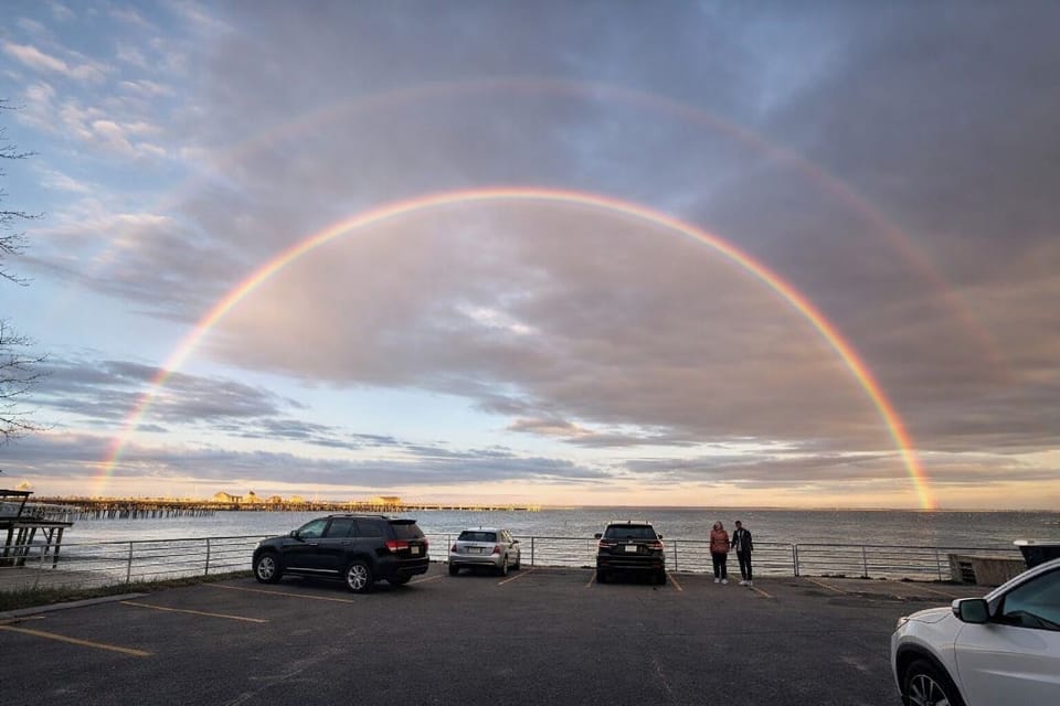 Bayfront view with pier access, sunset skies, and onsite parking
