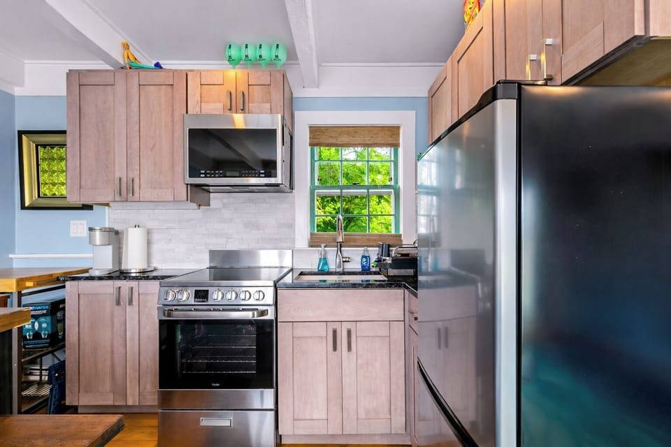 Bright modern kitchen with stainless appliances and window view
