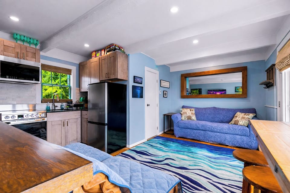 Bright studio with full kitchen, bar seating, and cozy sofa