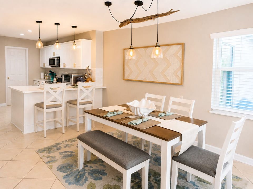 Bright coastal dining area with stylish kitchen and bar seating