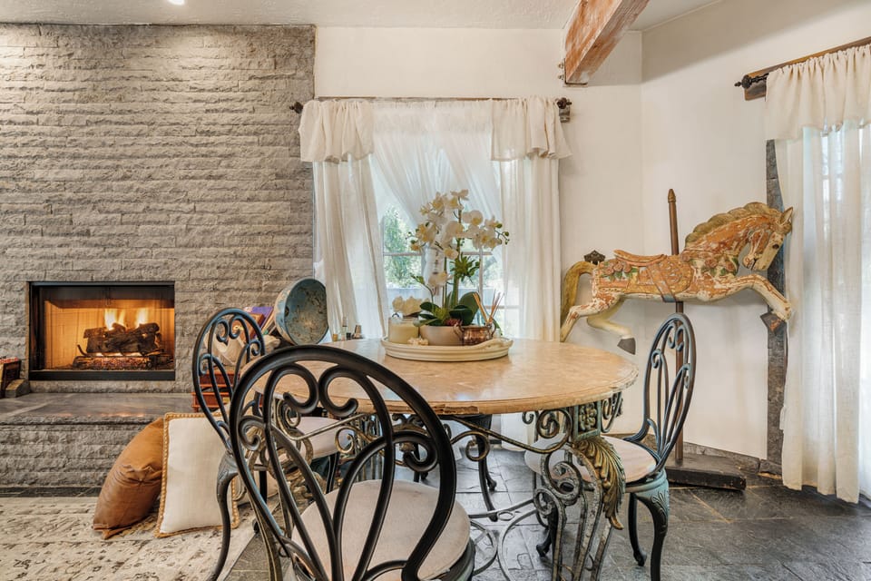 Elegant circular dining table with wrought iron chairs.