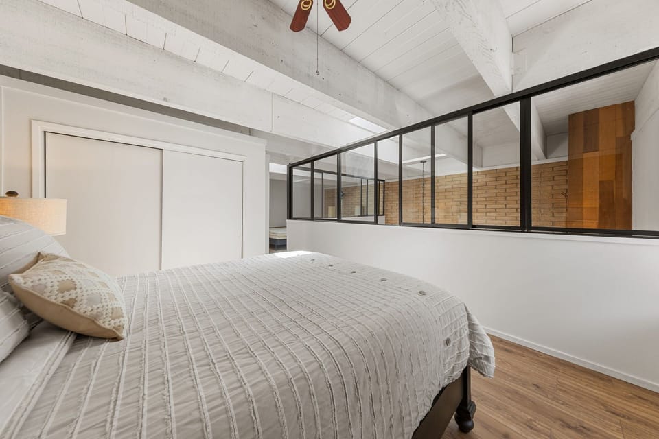 Loft sleeping area with interior windows overlooking the living room