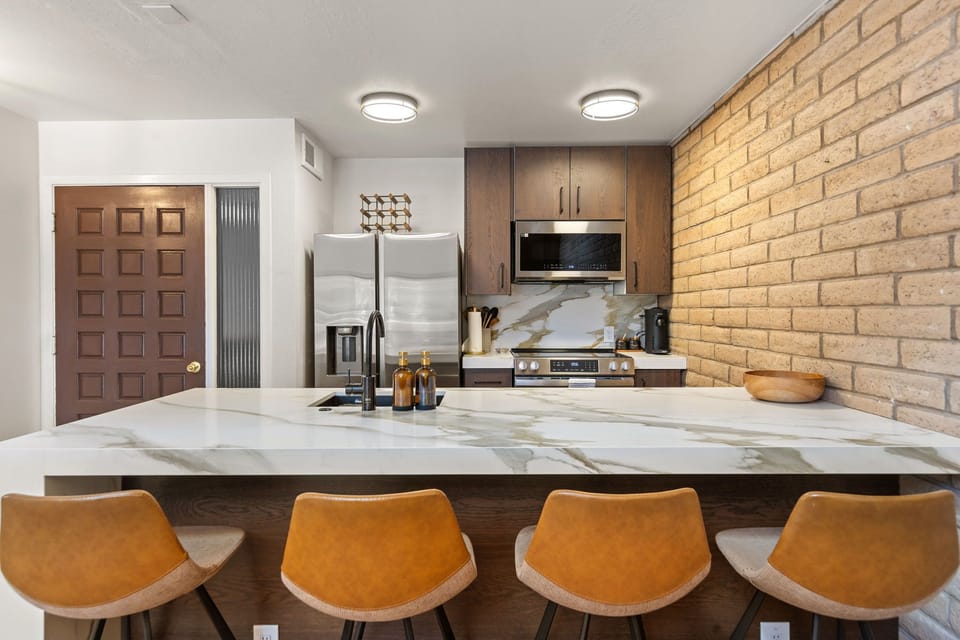 Kitchen breakfast bar with seating for four and marble backsplash