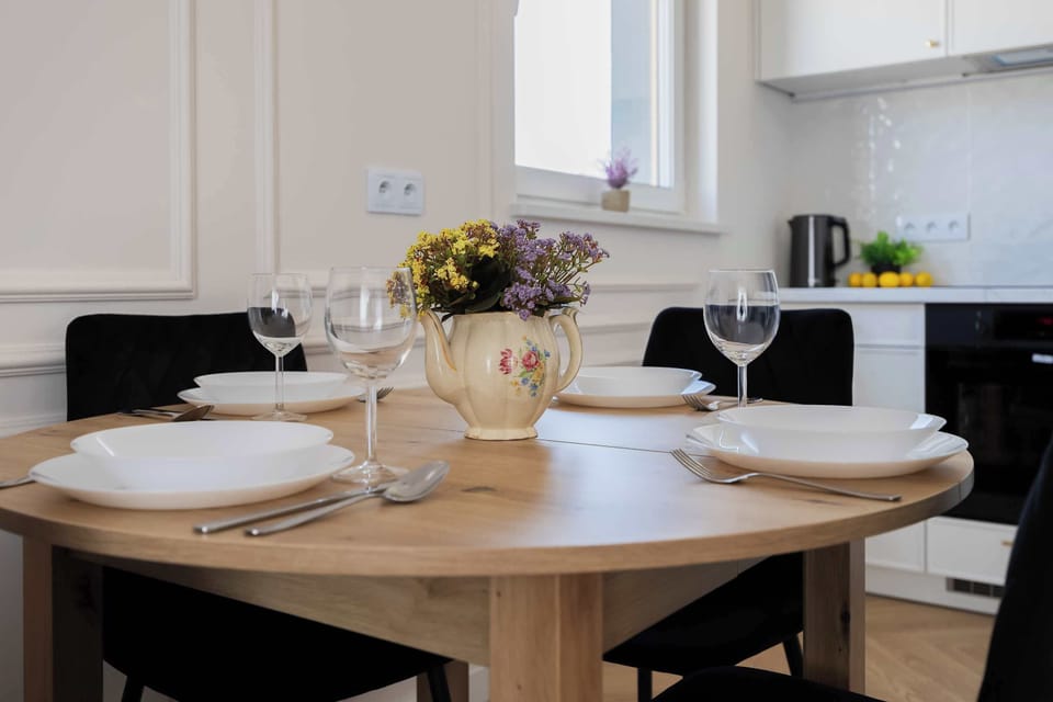 A close-up of a dining table set with plates, glasses, and a decorative centerpiece. The arrangement creates a welcoming dining atmosphere.