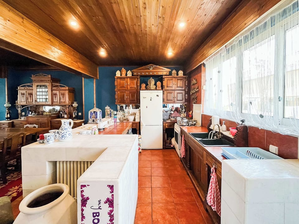 Bright and spacious kitchen area with modern appliances and large windows bringing in natural light while cooking
