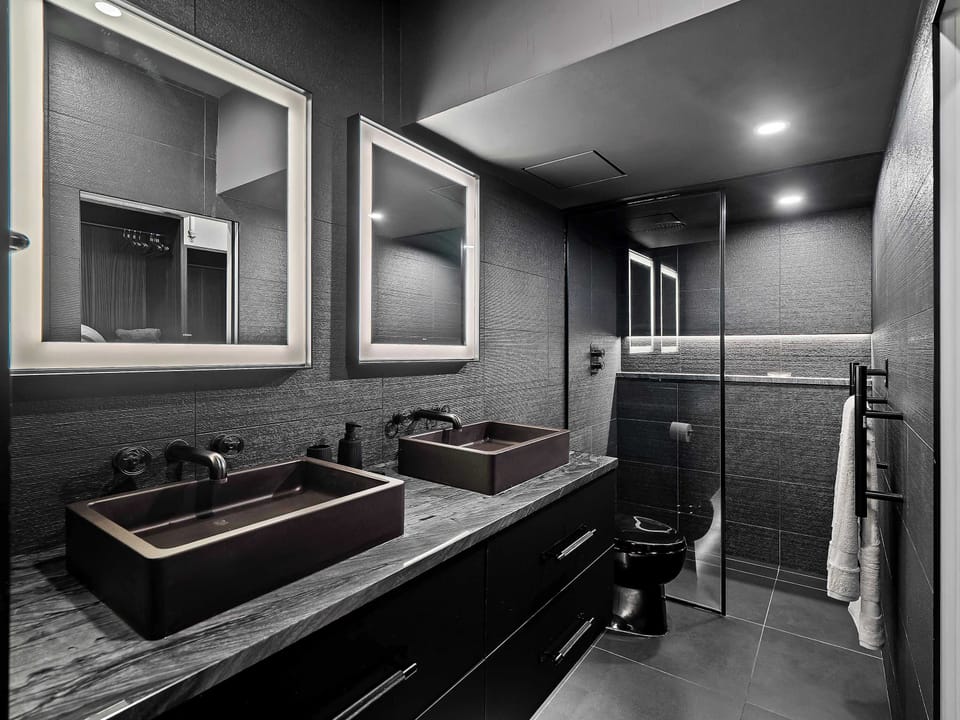 Full bathroom w/ double sink vanity, mirrors & modern finishes