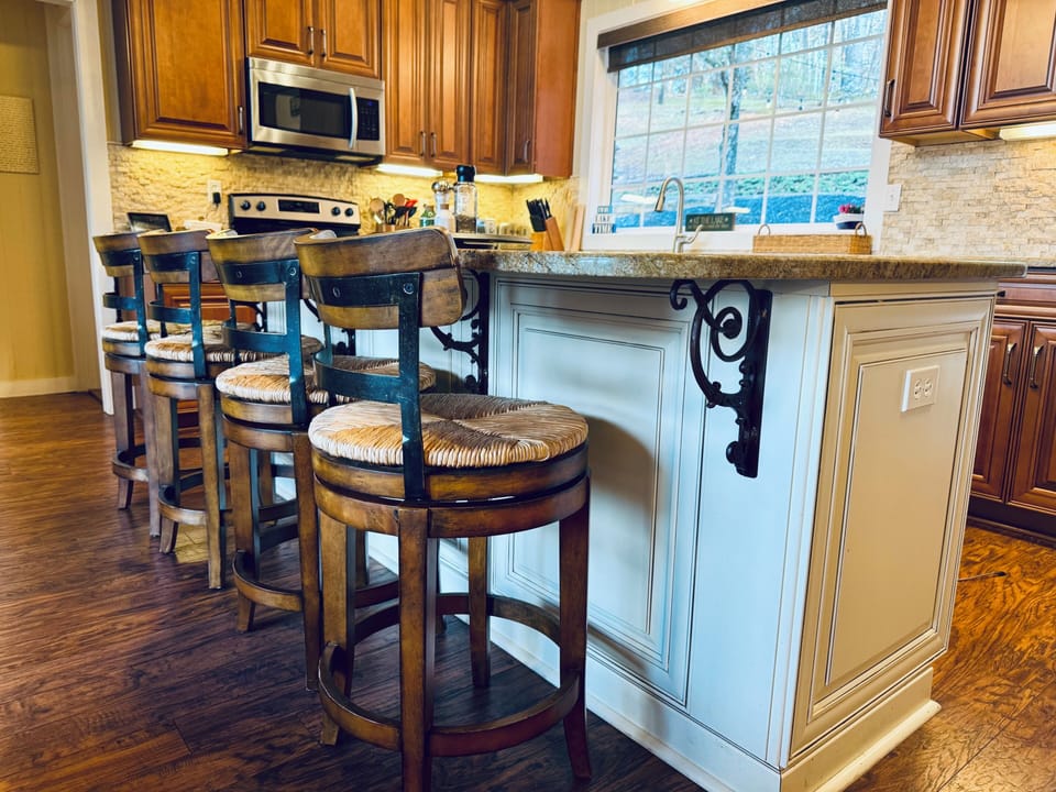 The large island has granite countertops and is perfect for the kids to sit. 