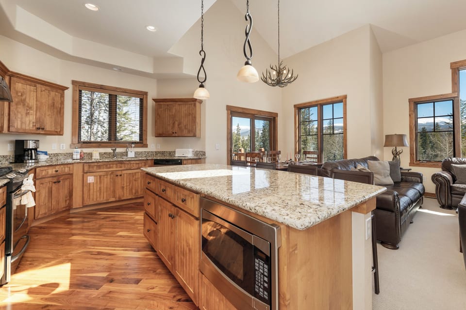 Your gourmet kitchen awaits with granite counters, rustic wood cabinets, and mountain views streaming through every window.