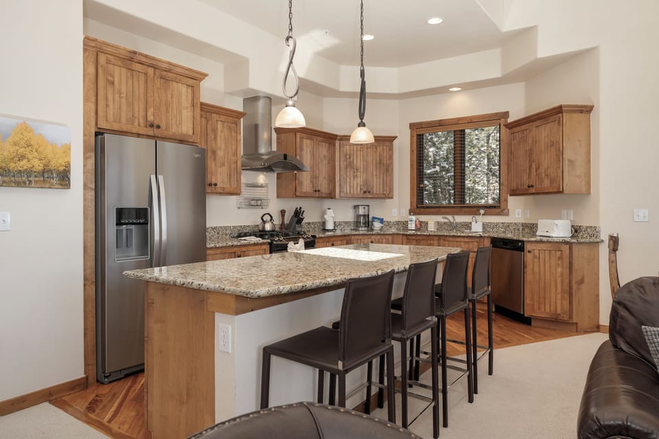 Your gourmet kitchen features granite countertops, stainless steel appliances, and a spacious breakfast bar perfect for morning coffee.