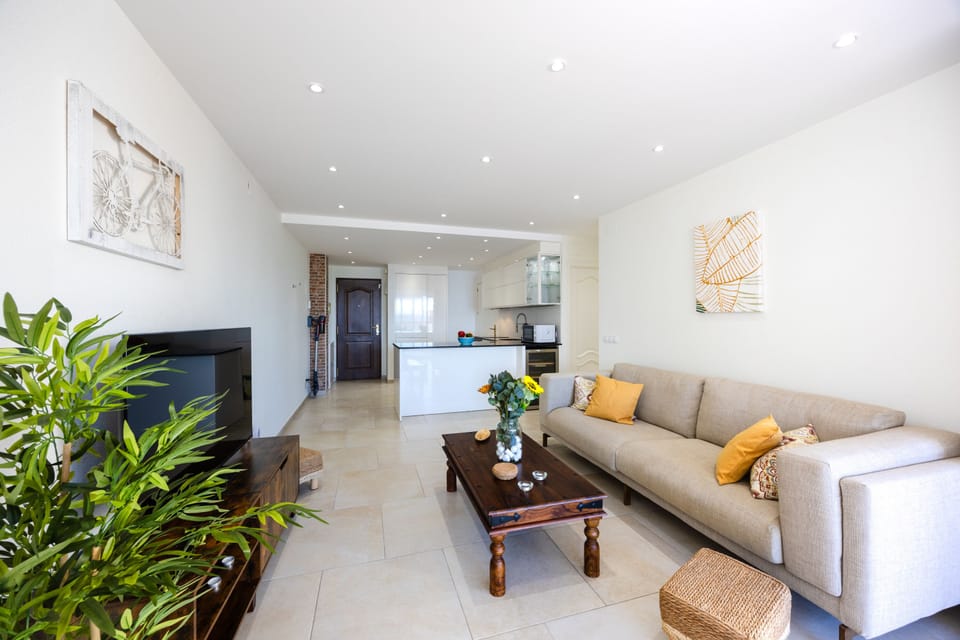 Bright living room with modern decor and open-plan kitchen, perfect for relaxation and entertaining.