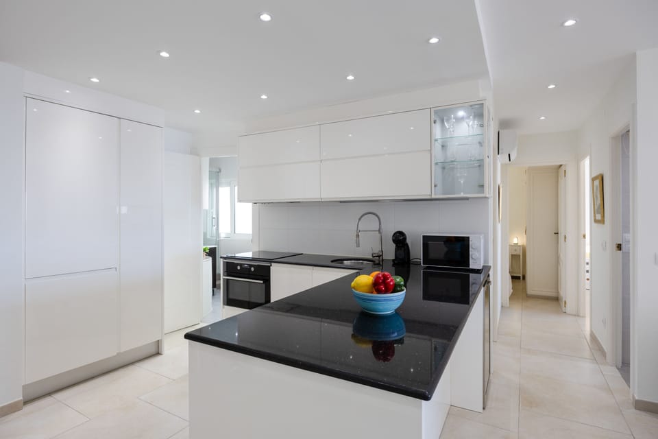Sleek modern kitchen with black granite countertops and high-end appliances.