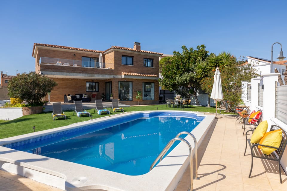 Inviting pool area with sun loungers and lush garden views, perfect for relaxation.