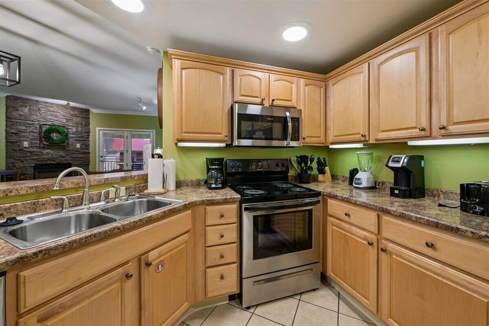 Your fully equipped kitchen features granite counters, stainless appliances, and warm wood cabinets—perfect for preparing memorable meals during your stay.