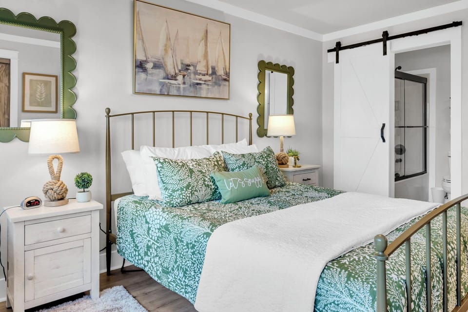 Unwind in your serene coastal-themed bedroom with plush bedding, charming nautical art, and bright natural light streaming through.
