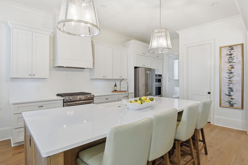 You'll love preparing meals in this bright, modern kitchen with gleaming white countertops and stylish pendant lighting overhead.