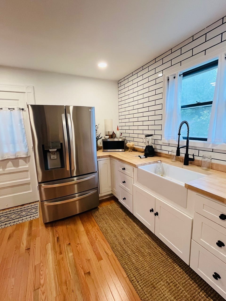 Your modern farmhouse kitchen features a spacious farmhouse sink, subway tile backsplash, and premium stainless steel appliances for memorable meal preparation.