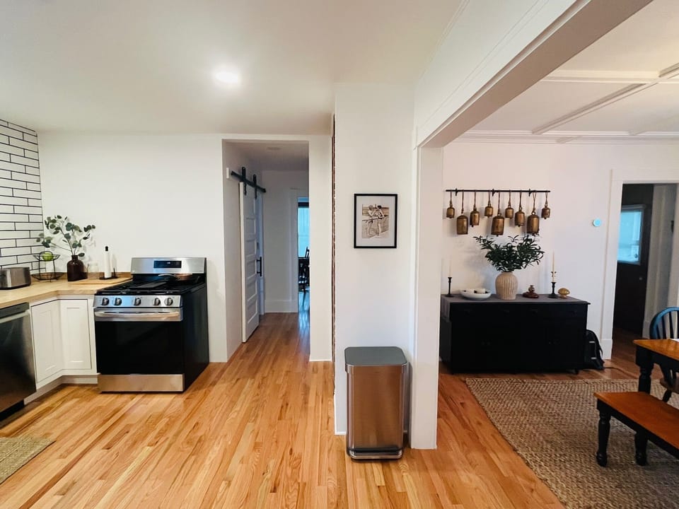 Your open-concept space flows seamlessly from kitchen to dining, featuring gleaming hardwood floors and charming rustic touches throughout.