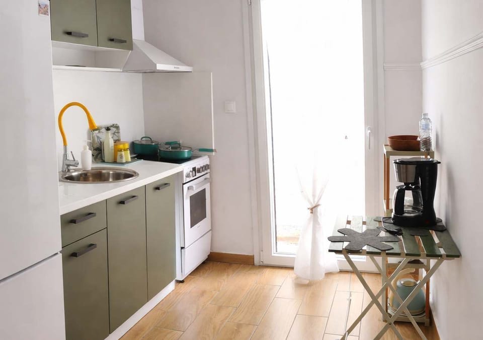 Bright kitchen with modern appliances and clean design, fully equipped for preparing meals, with natural light enhancing the space and creating a fresh and functional cooking environment
