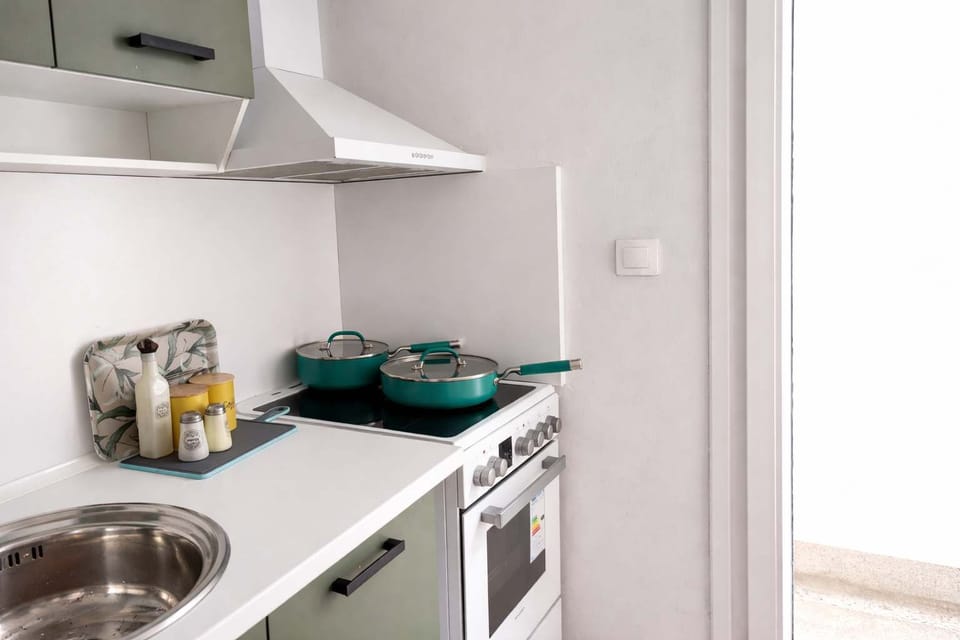 Compact kitchen corner with stove, oventop and sink, thoughtfully arranged for convenience, providing everything needed for basic cooking in a clean and efficient layout