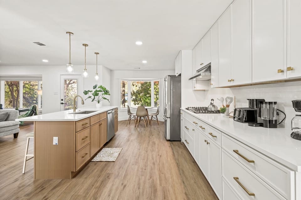 Sprawling chef’s kitchen with island seating for three and fully stocked cookware, perfect for cooking and entertaining.