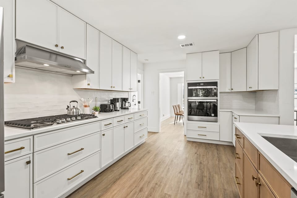 Sprawling chef’s kitchen with island seating for three and fully stocked cookware, perfect for cooking and entertaining.