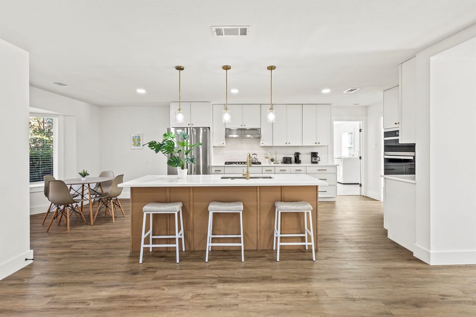 Sprawling chef’s kitchen with island seating for three and fully stocked cookware, perfect for cooking and entertaining.