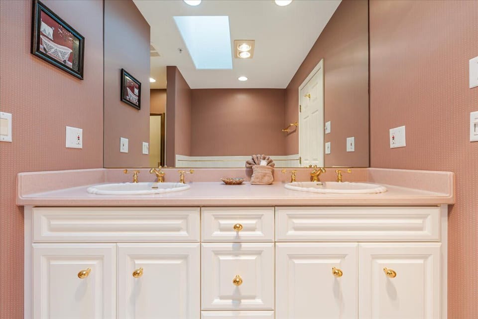 Enjoy the convenience of double sinks and generous storage in this beautifully appointed guest bathroom.