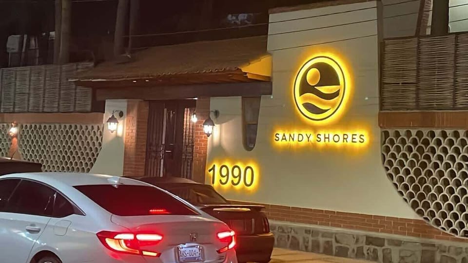 Nuestro distintivo letrero iluminado guía a los huéspedes a una experiencia inolvidable. Ubicado en 1990 Mutualismo, Sandy Shores brilla con una cálida bienvenida, destacándose como el lugar perfecto para tu estancia en La Paz.