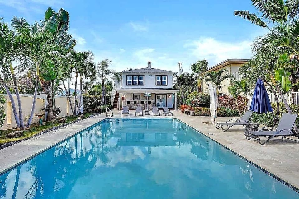 Full property exterior with pool and palm trees