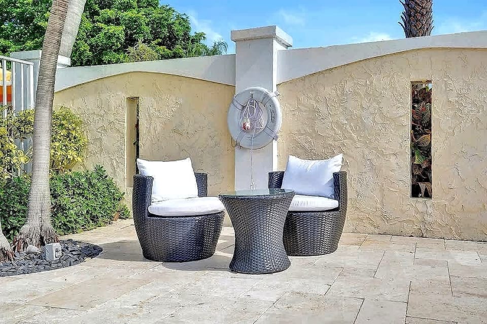 Outdoor seating nook with wicker chairs and wall art