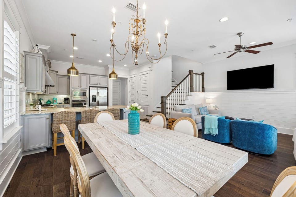 Bright, open living where coastal elegance meets comfort. Gather around the farmhouse dining table, relax in the plush seating, or prepare a meal in your fully equipped kitchen—all under a sparkling chandelier.