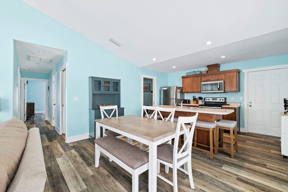 Your open-concept space features calming blue walls, modern kitchen with stainless appliances, and comfortable dining for memorable meals together.