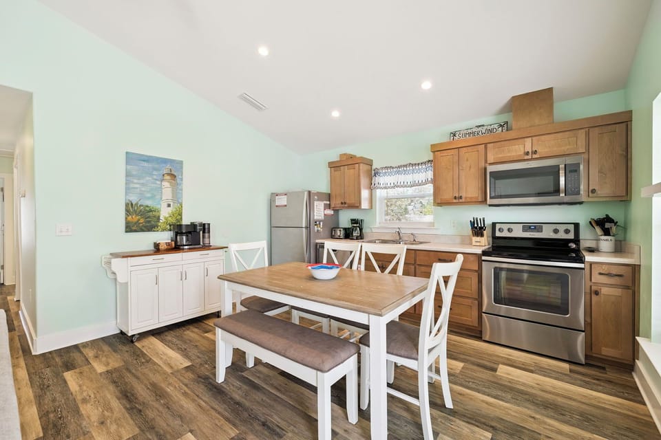 Cook and dine together in this bright, fully-equipped kitchen featuring modern appliances, coastal charm, and a welcoming dining table for family meals.