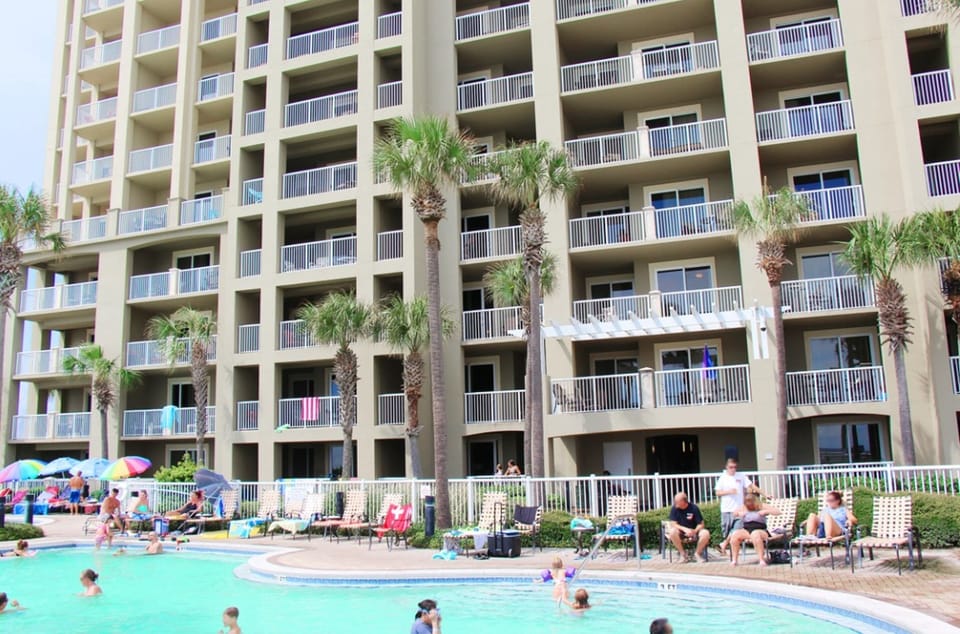 Resort-style pool area featuring sparkling waters and tropical palm trees for your Florida getaway.