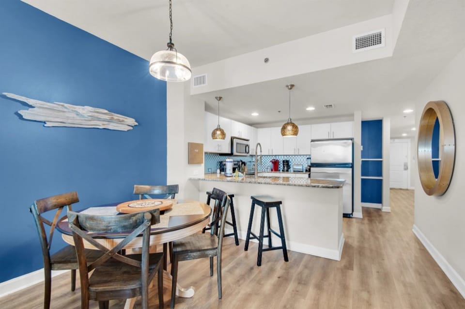 Your open-concept kitchen and dining area blends coastal blues with modern comfort for memorable meal preparation and intimate gatherings.