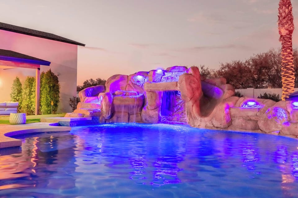 Waterfall, rock slide, and sparkling pool create an unforgettable backyard escape.